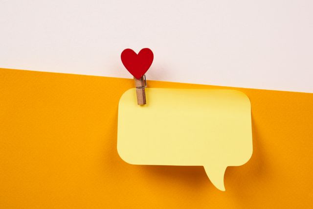 黄色い吹き出しの付箋とハートのピン